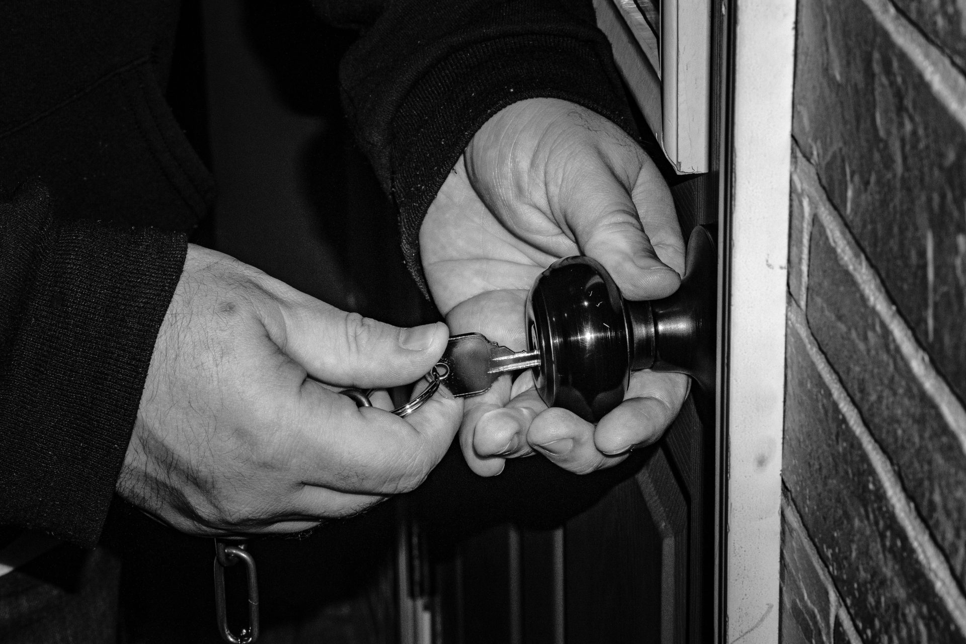 persona sosteniendo el pomo de una puerta de acero negro